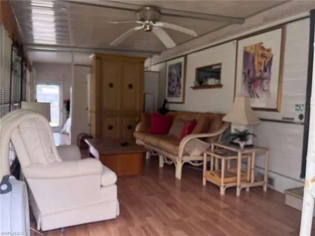 Living room with ceiling fan and hardwood / wood-style floors