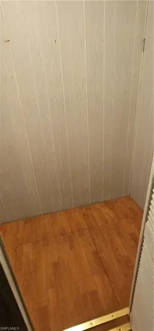Details featuring elevator and hardwood / wood-style flooring