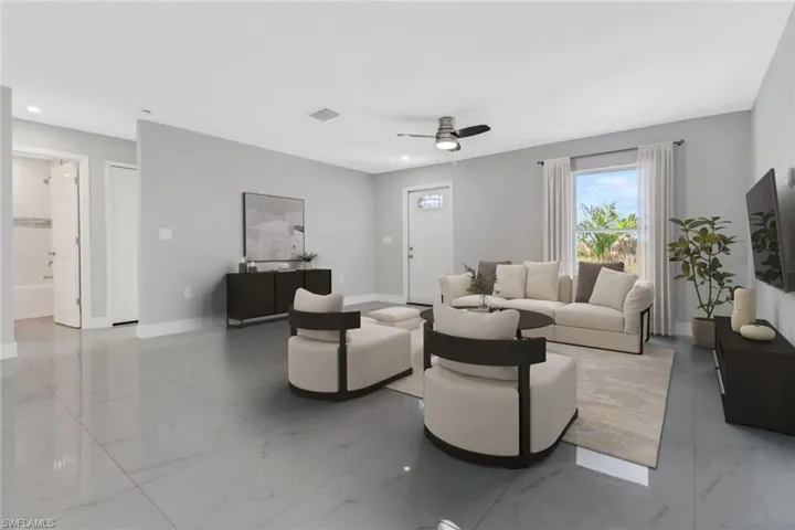 Living area with light marble finish floors, baseboards, ceiling fan, and recessed lighting