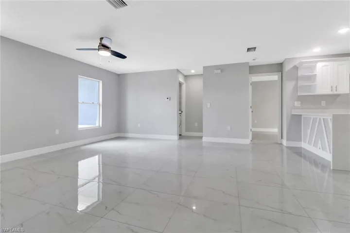 Unfurnished room with light marble finish floors, baseboards, recessed lighting, and ceiling fan