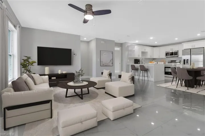 Living area with light marble finish floors, recessed lighting, and a ceiling fan