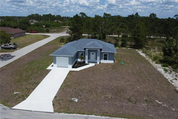 Single story home with concrete driveway, a garage, stucco siding, and a front yard