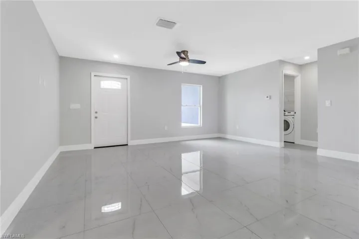 Spare room with light marble finish flooring, washer / dryer, baseboards, a ceiling fan, and recessed lighting