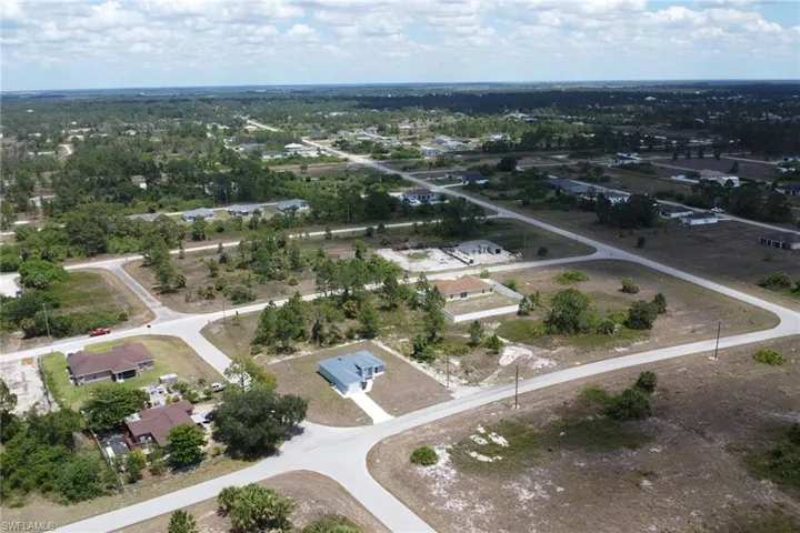 Aerial view of property and surrounding area with nearby suburban area