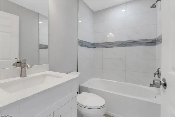 Full bath featuring toilet, washtub / shower combination, and vanity