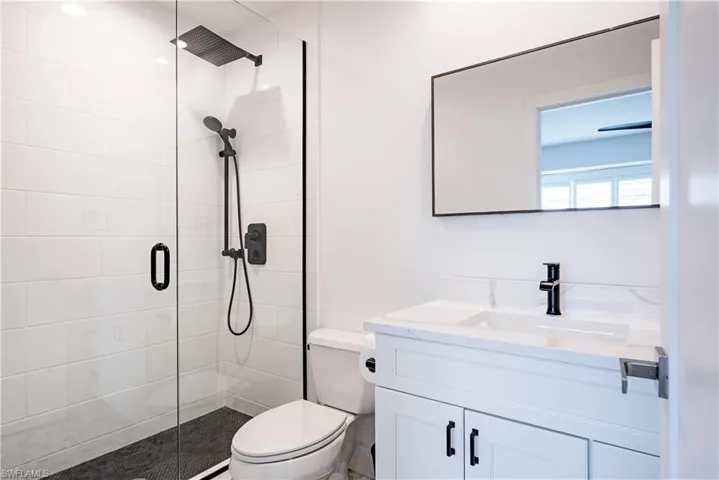 Bathroom featuring walk in shower, toilet, and vanity
