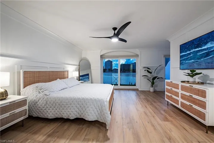 Primary bedroom featuring ceiling fan, light hardwood / wood-style flooring, ornamental molding, and access to exterior