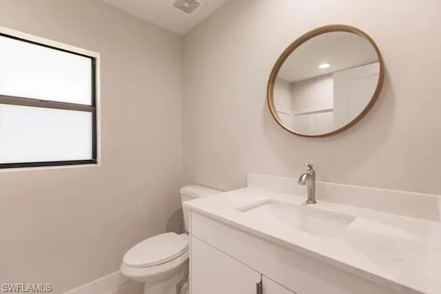 Bathroom featuring plenty of natural light, vanity, and toilet