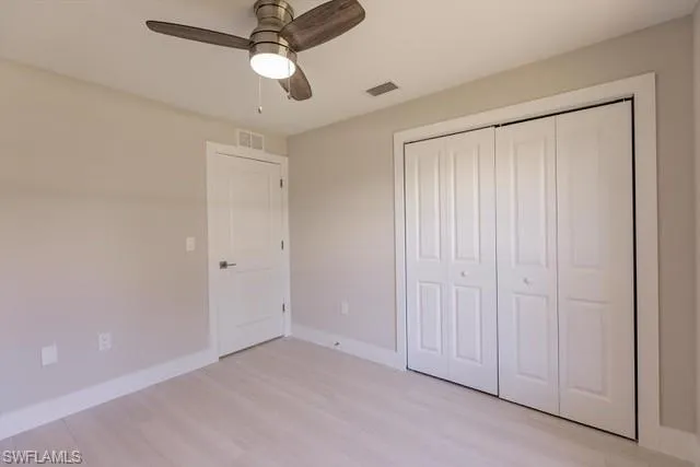 Unfurnished bedroom with a closet, light hardwood / wood-style flooring, and ceiling fan