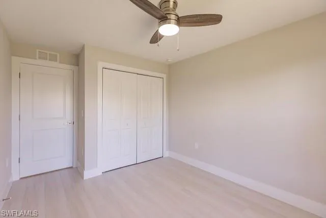 Unfurnished bedroom featuring ceiling fan, light hardwood / wood-style flooring, and a closet