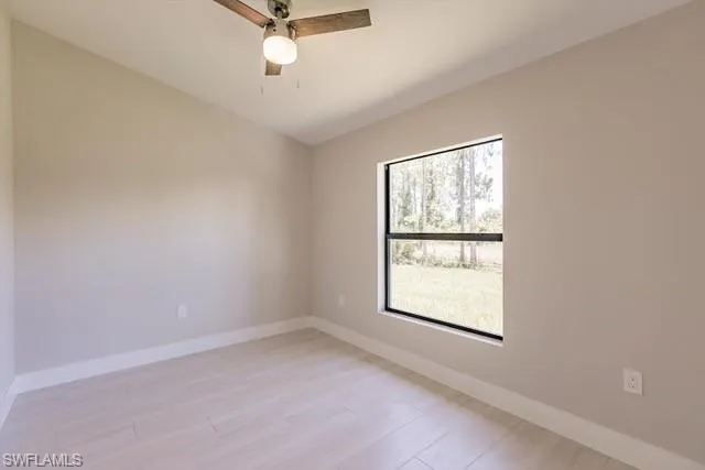 Spare room featuring ceiling fan, plenty of natural light, and light hardwood / wood-style floors