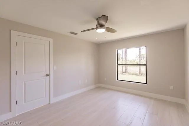 Unfurnished room with ceiling fan and light wood-type flooring