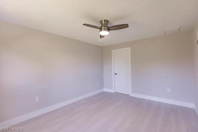 Empty room with ceiling fan and light hardwood / wood-style flooring