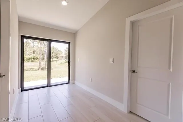 Spare room featuring vaulted ceiling