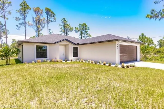 Single story home with a front yard and a garage