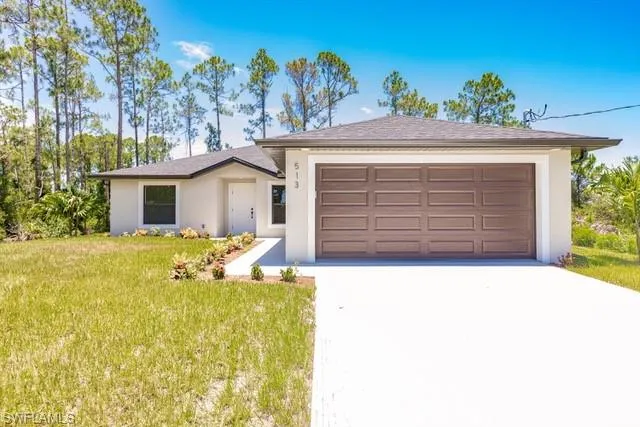 Ranch-style house with a garage and a front lawn