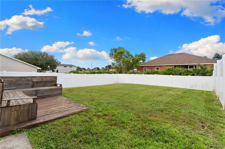 Fenced backyard featuring a deck