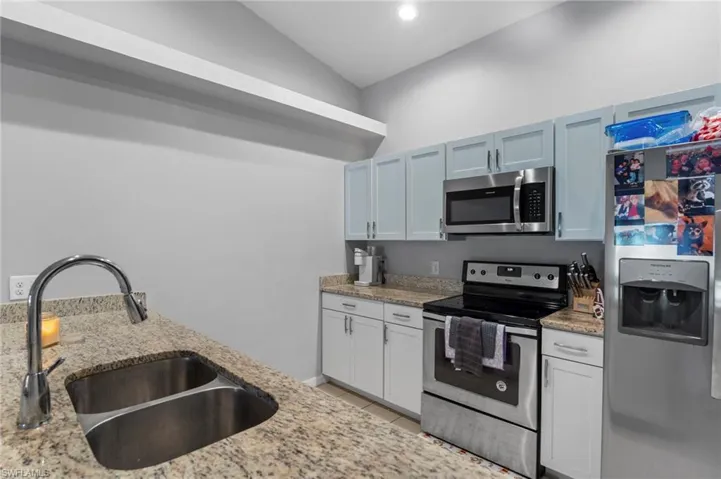 Kitchen featuring appliances with stainless steel finishes, light stone counters, recessed lighting, and light tile patterned floors