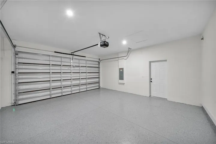 Garage featuring electric panel and a garage door opener