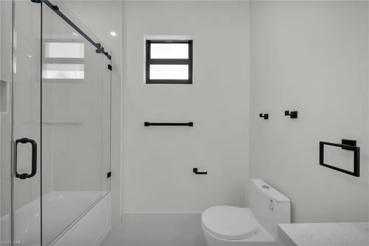 Bathroom with combined bath / shower with glass door and vanity