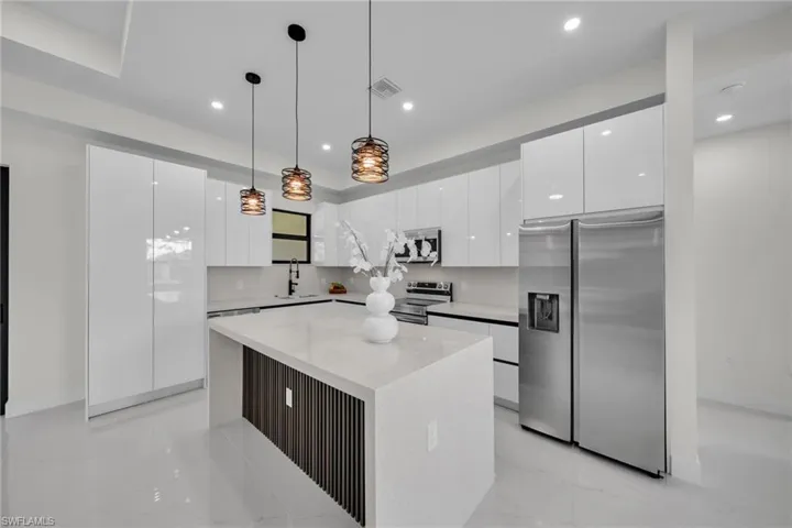 Kitchen featuring white cabinetry, stainless steel appliances, modern cabinets, pendant lighting, and recessed lighting