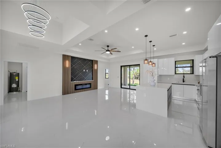 Kitchen with modern cabinets, white cabinets, a chandelier, pendant lighting, and open floor plan
