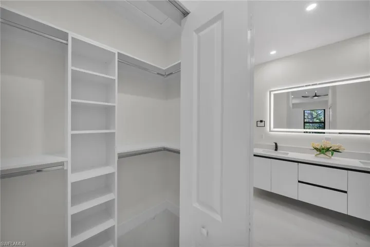 Walk in closet with a ceiling fan and a sink