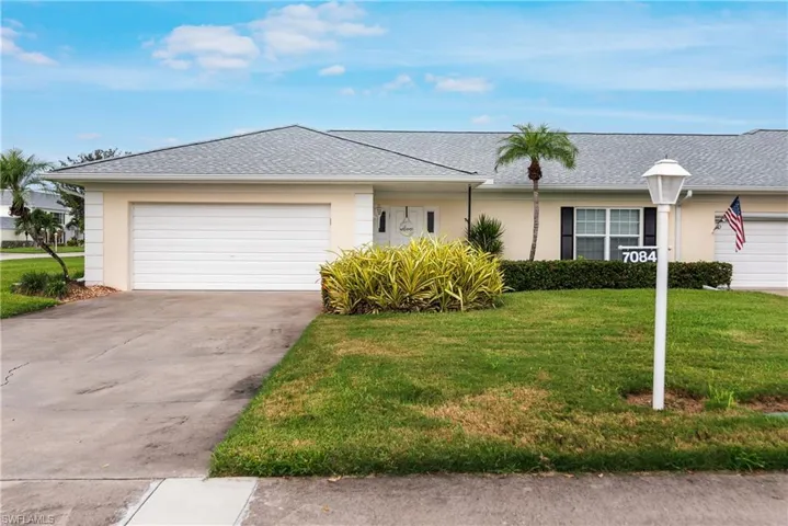 Single story home with a shingled roof, a garage, stucco siding, and a front yard