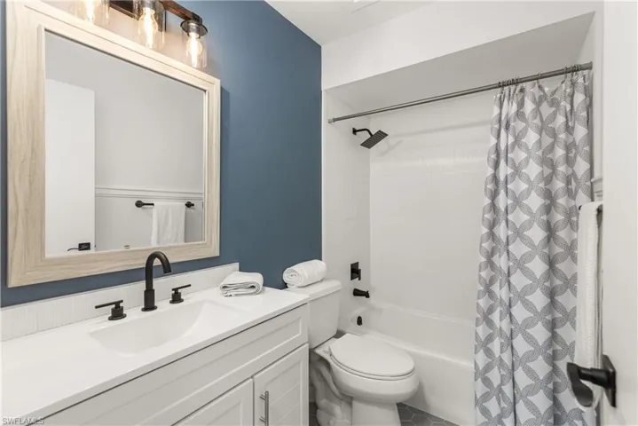Bathroom featuring vanity and shower / tub combo with curtain