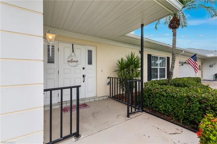 Property entrance with a porch and stucco siding