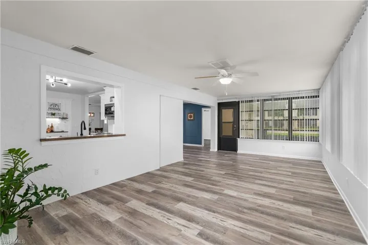 Unfurnished living room featuring wood finished floors and a ceiling fan
