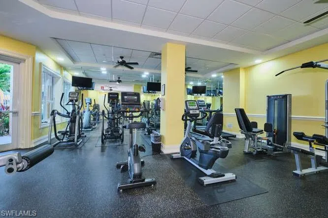 Workout area with a ceiling fan and a drop ceiling