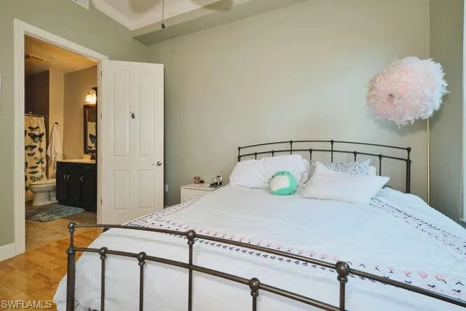 Bedroom with wood finished floors and ensuite bathroom