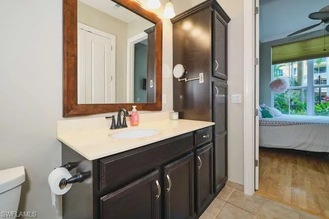 Bathroom featuring vanity, connected bathroom, a ceiling fan, and light tile patterned floors