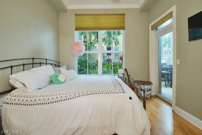 Bedroom with light wood finished floors and crown molding