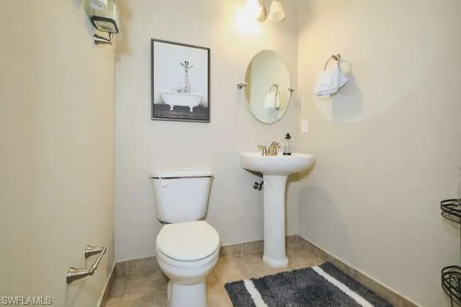 1/2 Bathroom with toilet and light tile patterned floors