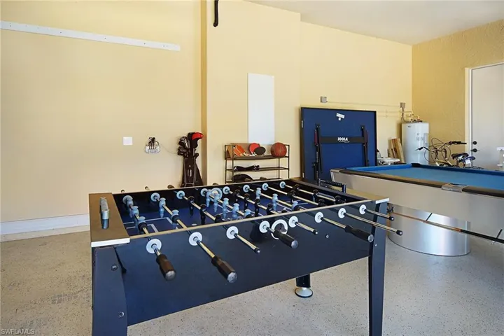 Recreation room with speckled floor, water heater, and billiards table