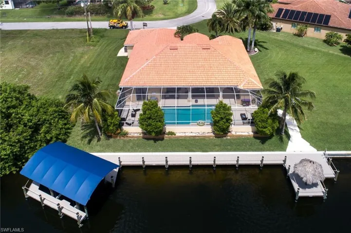 Aerial view of property and surrounding area with a large body of water and a pool
