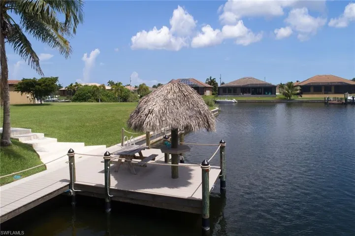 Dock area with a lawn, a water view, and a residential view