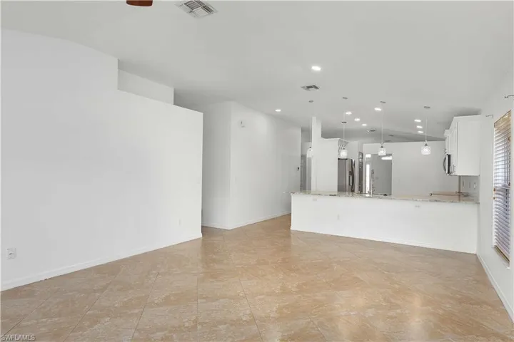 Unfurnished living room with lofted ceiling