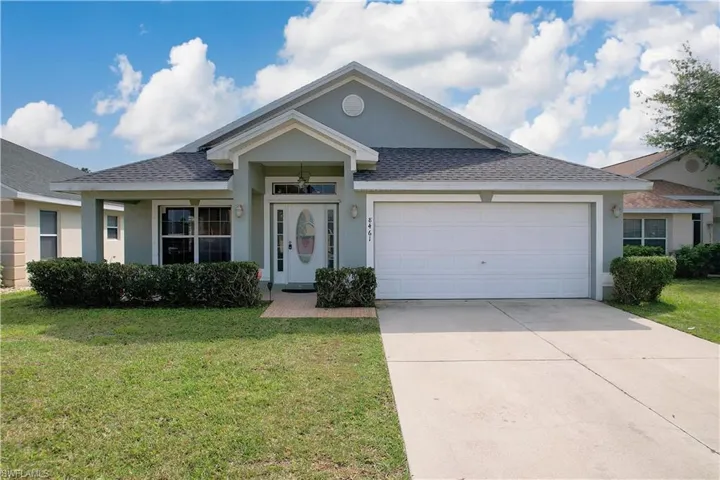 View of front of house with a front yard and a garage