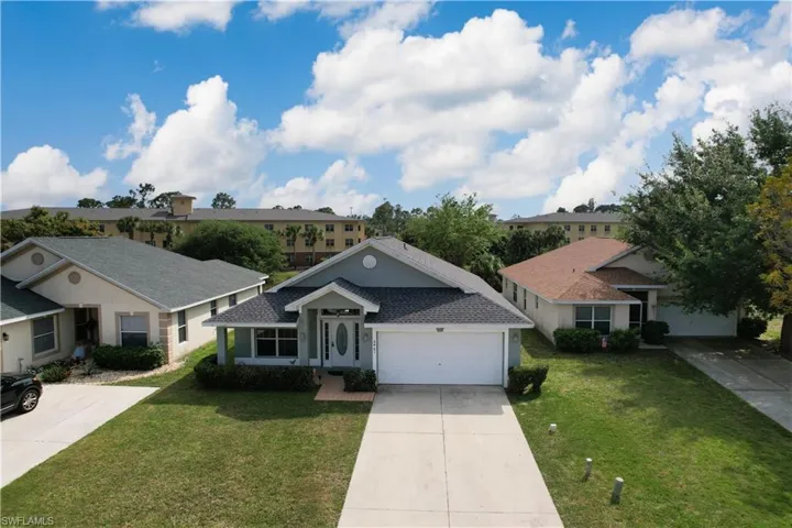 Ranch-style home with a garage and a front lawn