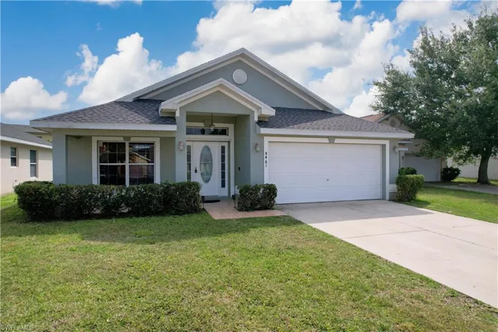 View of front of house with a front yard and a garage