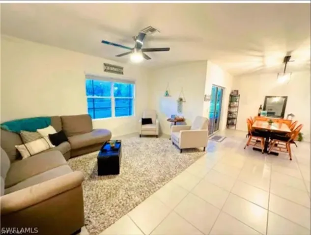 Living area featuring tile patterned floors and a ceiling fan