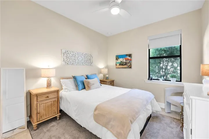 Bedroom with a ceiling fan and light carpet