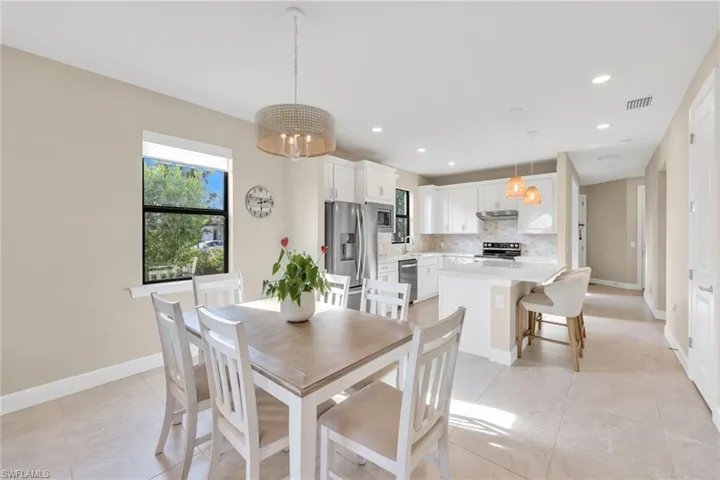 Dining area with a chandelier, light tile patterned floors, and recessed lighting
