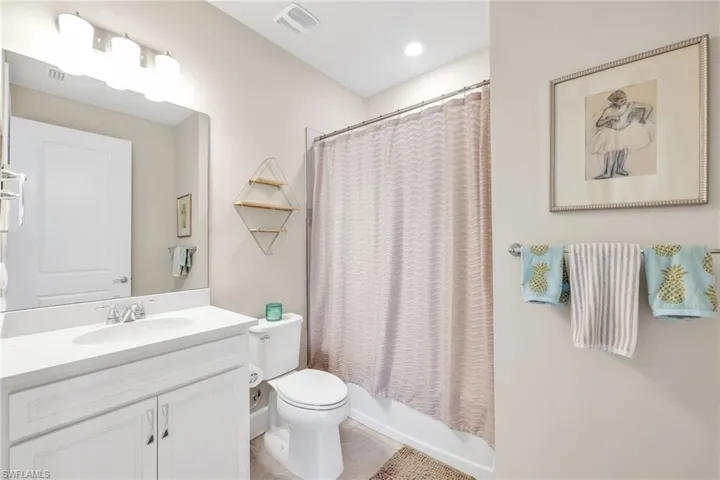 Full bathroom featuring vanity, shower / tub combo, and light tile patterned floors