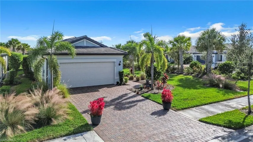 View of front facade featuring a front yard, a garage, and decorative driveway