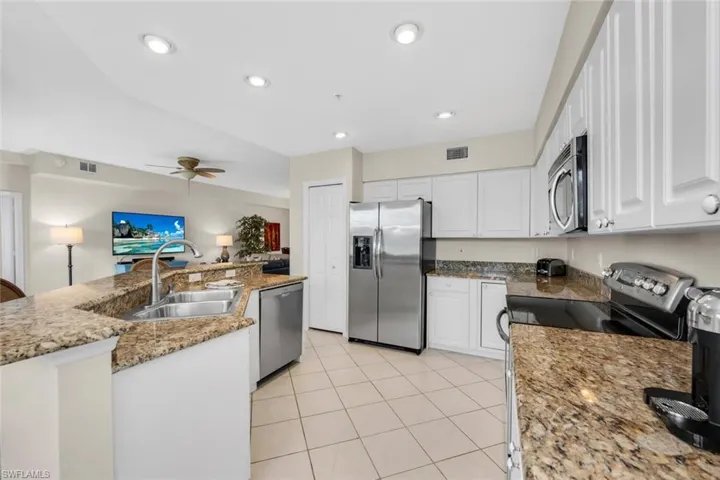Kitchen featuring appliances with stainless steel finishes, a sink, white cabinets, ceiling fan, and recessed lighting