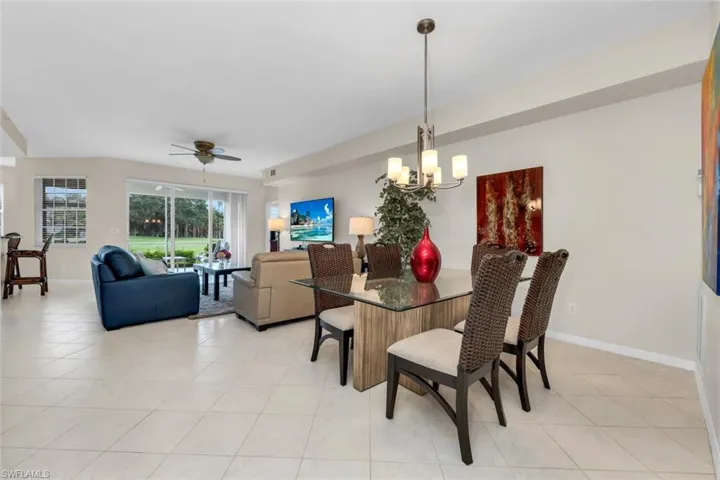 Dining area featuring a chandelier, ceiling fan, and light tile patterned floors